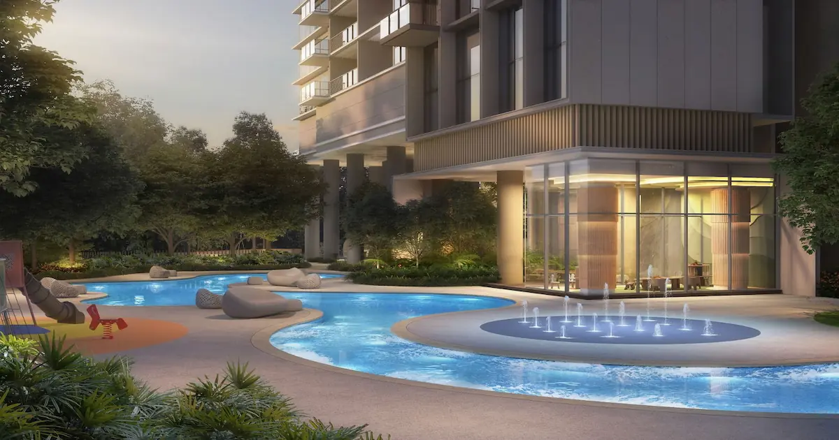 Ground-level view of a shallow, curved splash pool featuring floor water jets, located adjacent to a glass-enclosed children's playroom at Nava Grove.